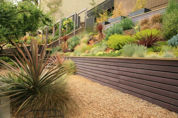 1x4 stained cedar structural retaining wall to create a flat space on a hillside garden
