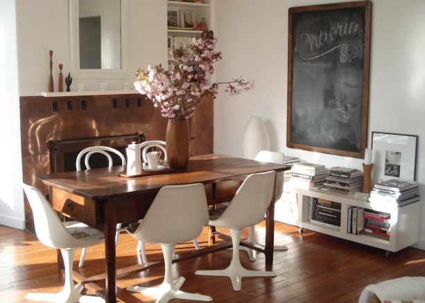a desk in the middle of a dining room doubled as a home office that is functioned as a dining table