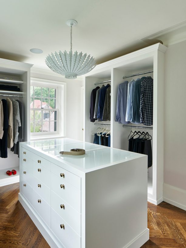mid-sized walk-in closet with small chandelier with burnished silver leaf lighting