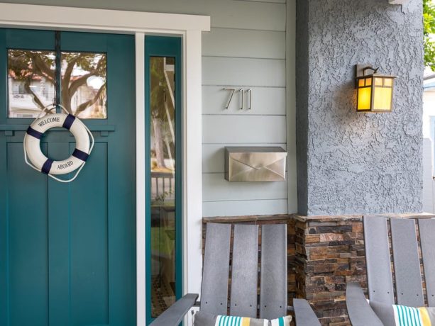 a bright teal front door that matches the ocean view nearby