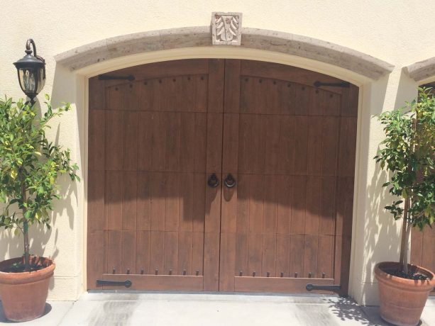 arched mountain style wood panel garage doors with black hardware