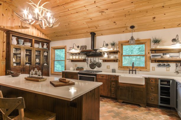 cozy log cabin kitchen with brick floor and dark wood shaker cabinets