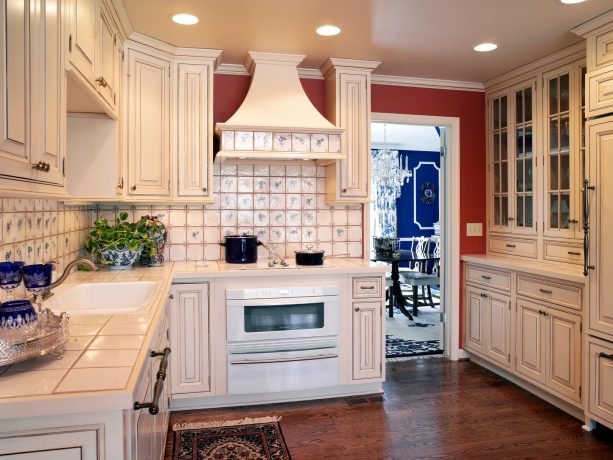 distressed white cabinets and tiled countertops to exude a classic european style
