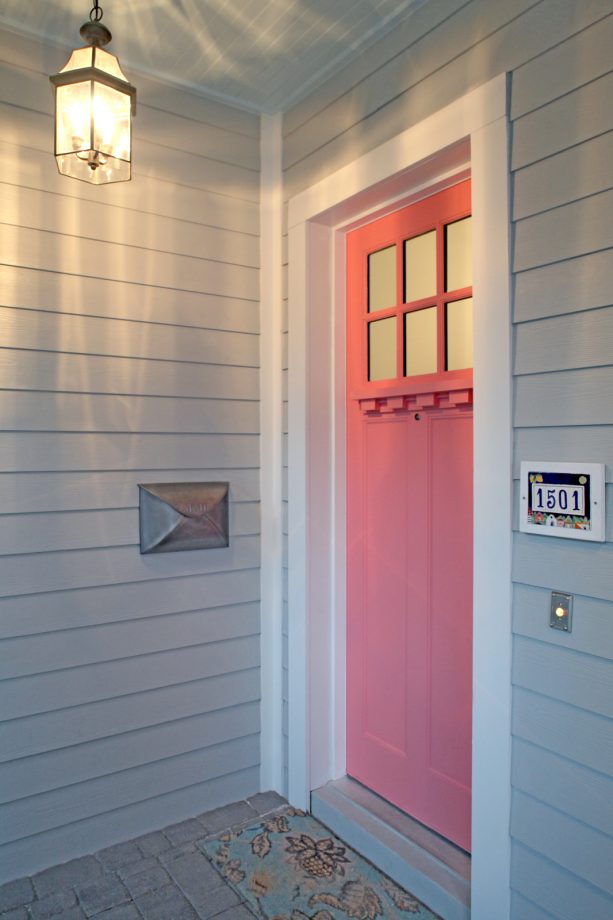 elegant entrance with a sherwin williams - dishy coral front door framed with white trim
