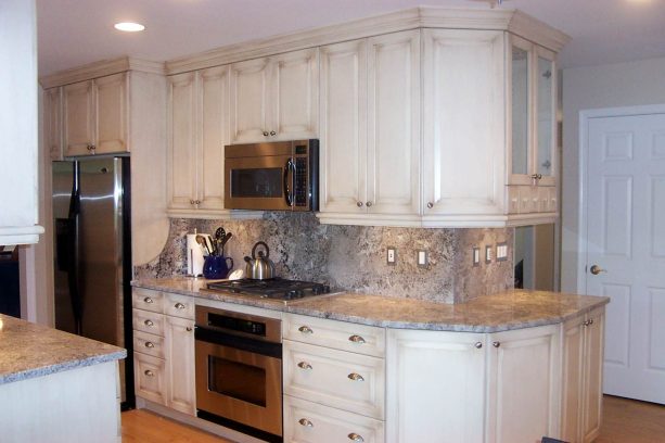 faux distressed white cabinets paired with arctic ice granite countertops