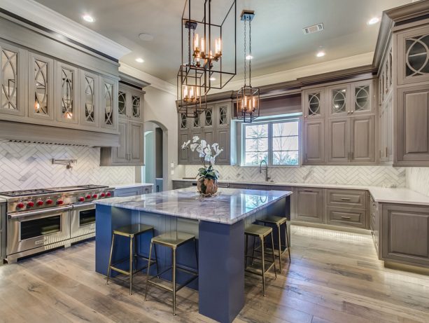 gray raised panel cabinets and white countertops accentuated by bold blue island