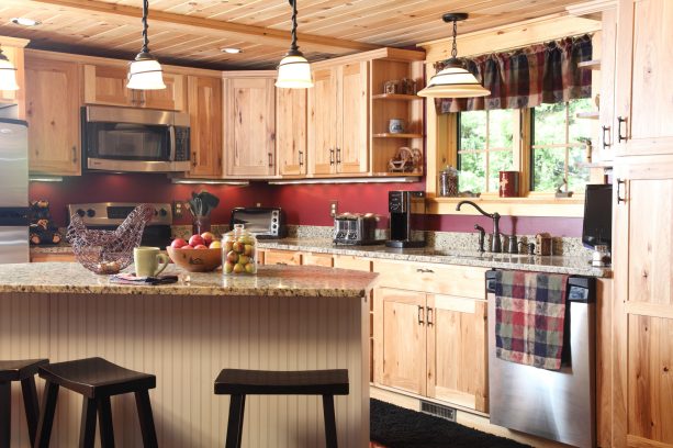 light wood cabinetry and granite countertops to create a transitional look in a log cabin kitchen