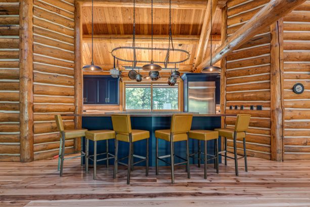 rustic kitchen in a log cabin with blue shaker cabinetry to contrast the natural wood around