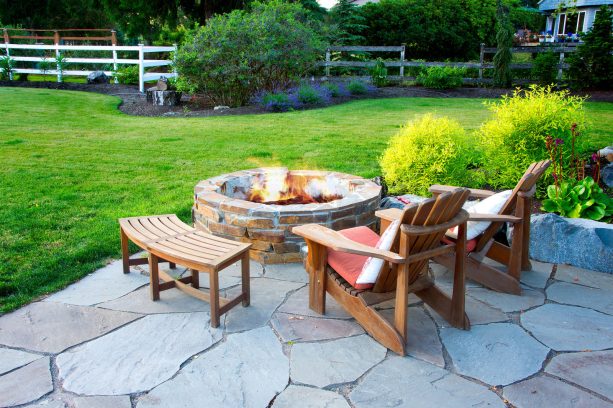 rustic landscape with a flagstone patio and a mortared stacked fire pit
