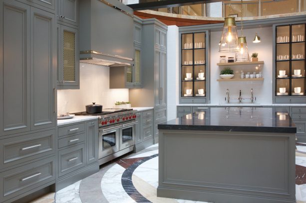 trendy kitchen with gray glass front and recessed panel cabinets combined with white countertops