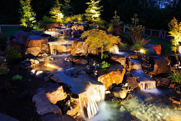 backyard landscaping with river rocks and boulders to create a water fountain