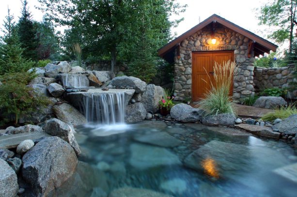 boulders and rocks are used to mimic a natural pond in rustic landscaping