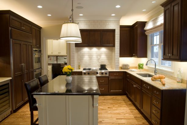 cherry wood cabinets in dark clove stain and light countertops paired with white subway tile backsplash