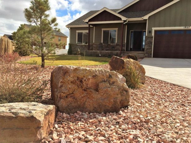 craftsman landscaping with rocks and boulders to contrast the mown grass area