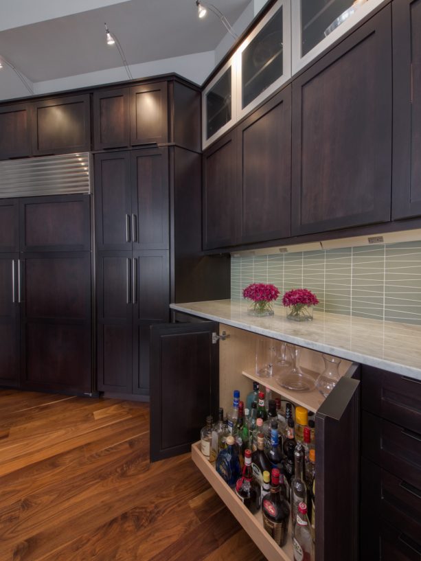 dark kitchen cabinets and light marble countertops accentuated with blue backsplash
