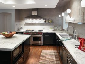 dark kitchen cabinets with light laminate countertops balanced by the gray backsplash