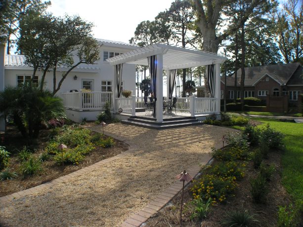 elegant floating deck with a pergola painted in white to match the main house