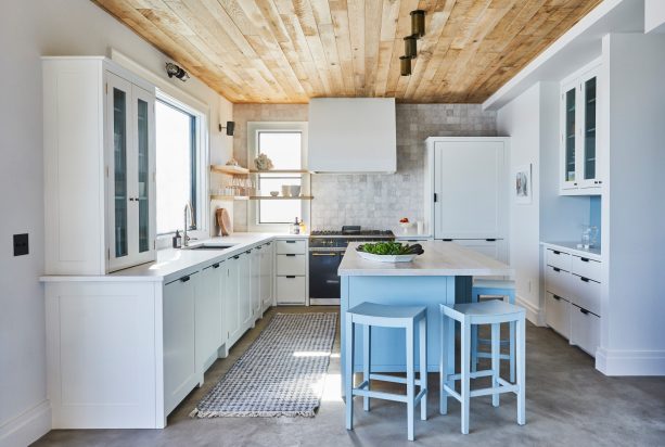 gray concrete kitchen floor accentuated by light blue island cabinets and stools