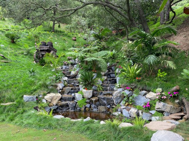 river rocks and boulders to create a bali rainforest waterfall in asian landscaping