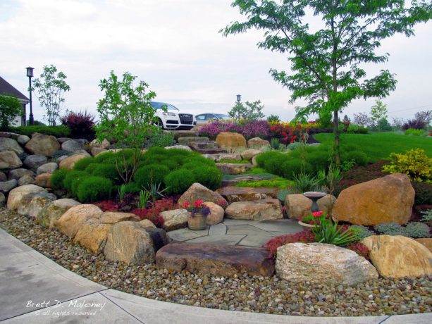 rock garden landscaping with decorative boulder wall surrounding perennials