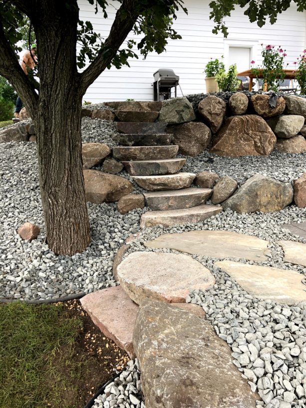 transitional rock garden without plants completed with boulders as a retaining wall