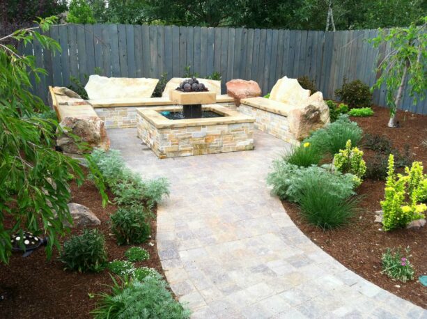 concrete paver townhouse patio with a fire pit surrounded by landscaping