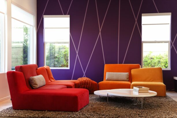 modern living room with striped purple accent wall and orange sofas