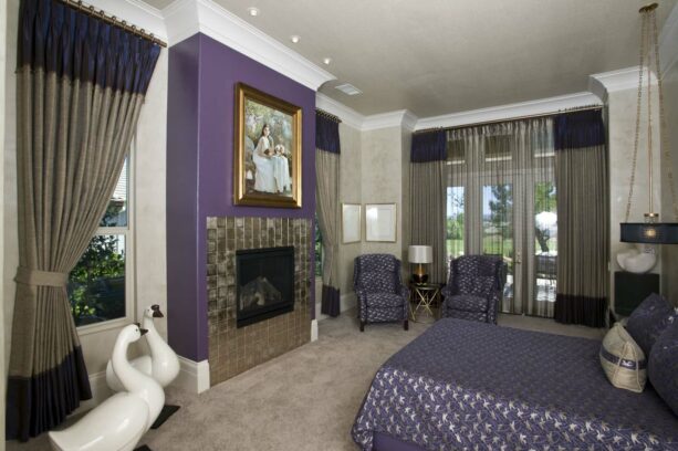 purple accent color with a fireplace surrounded by glass tile and gold framed picture