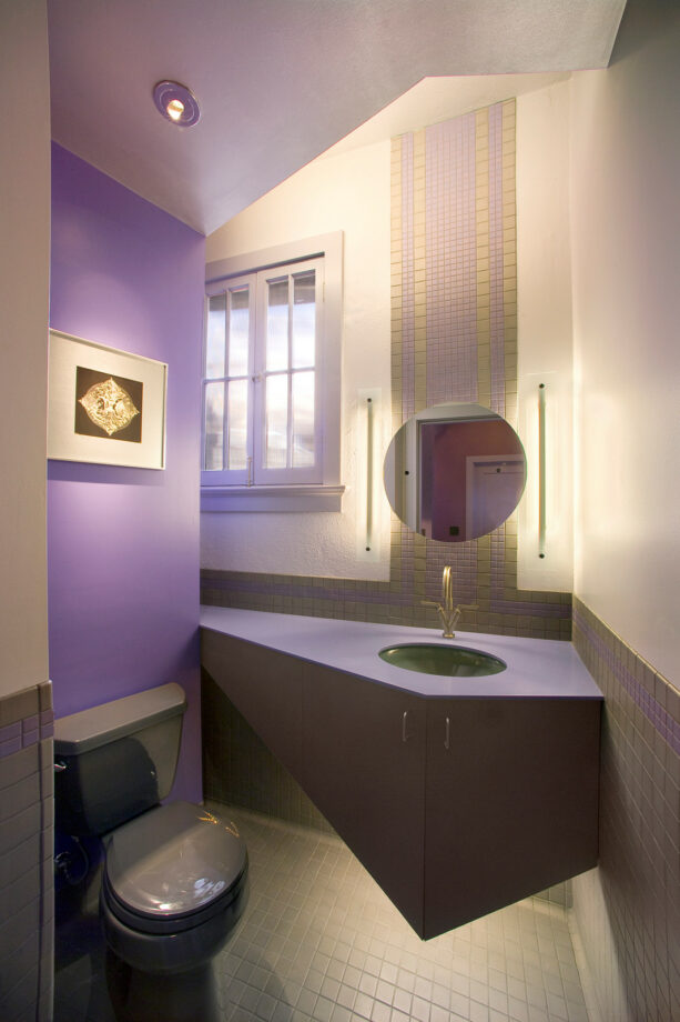 purple accent wall in a powder room that matches the countertop and trim