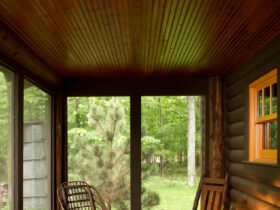 screened-in log cabin porch with a roof extension and decking