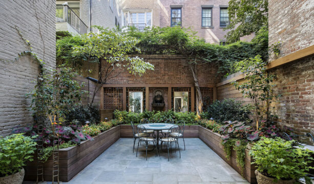 the idea of using a container garden on the perimeter of a classic stone townhouse patio