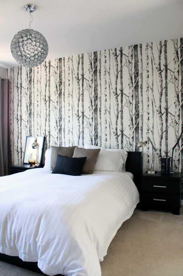 woods patterned wallpaper accent wall in a black and white bedroom