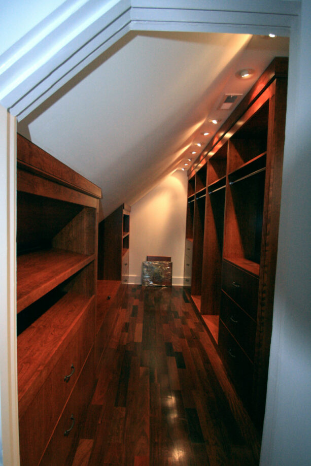 dark tone wood walk-in storage space in an attic closet