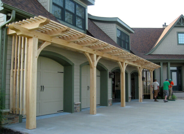 large pergola with a screen over garage doors