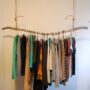 rustic styled hanging clothes rack from the ceiling made of a solid branch