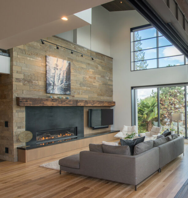 a ribbon fireplace with a metal plate surrounds a stone wall